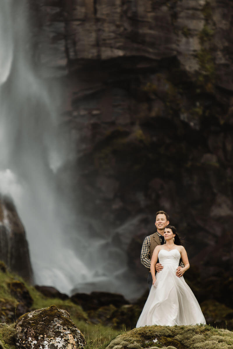 Iceland elopement, couple standing in front of waterfall.