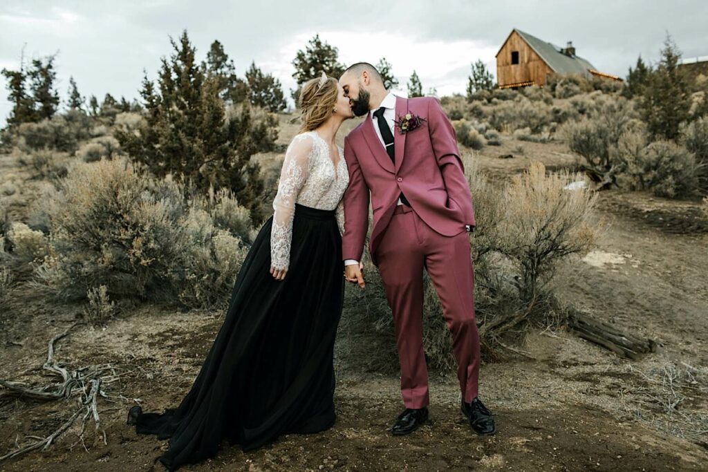 Brasada Ranch wedding venue in background as couple kisses. 