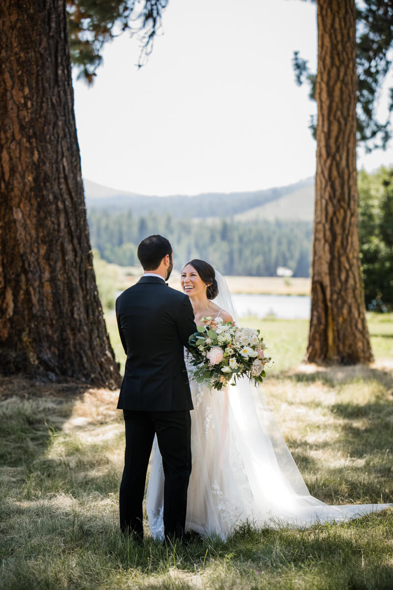 Couple has their first look between pine trees at Black Butte Ranch. 