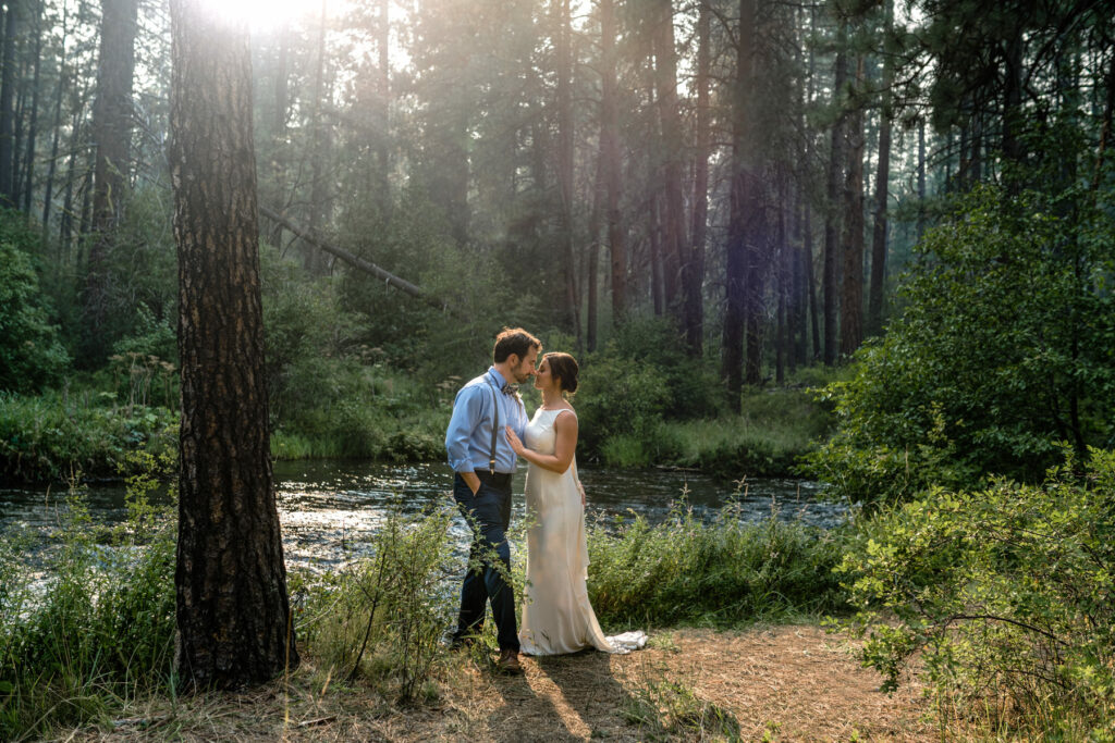 Couple kisses by the Metolius River.