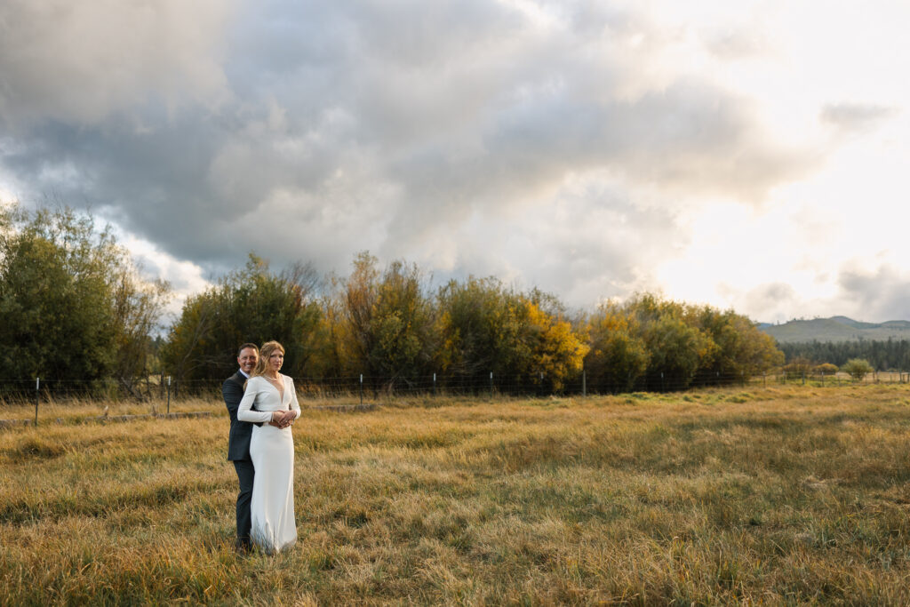 Sunset portraits of a modern couple in a field post wedding ceremony. 