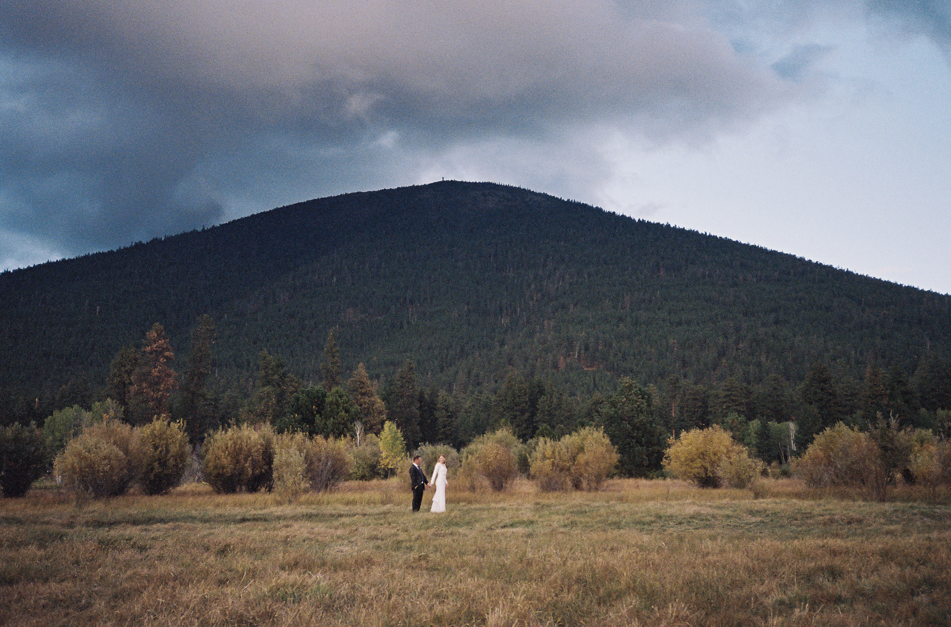 35mm film photo of Black Butte and the wedding couple teeny tiny in the distance holding hands. 