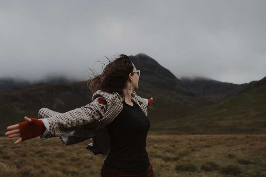 Gwen arms outstretched on a windy, rainy day in Scotland.