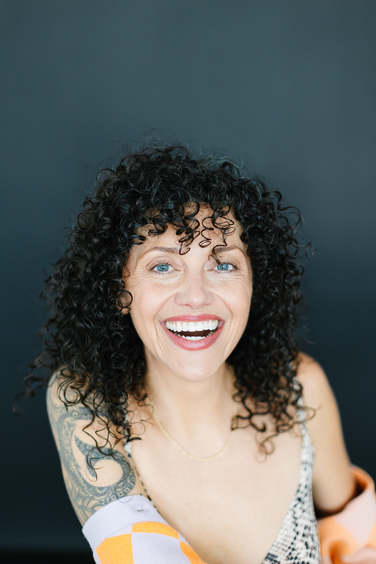 Portrait of woman with dark curly hair.