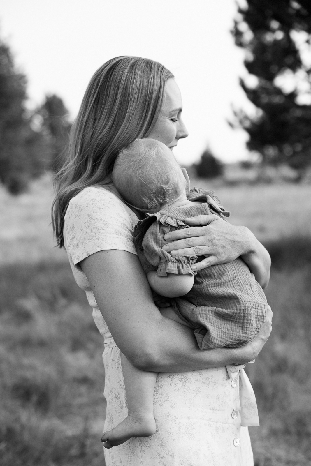 Black and white image of mom sweetly holding infant.