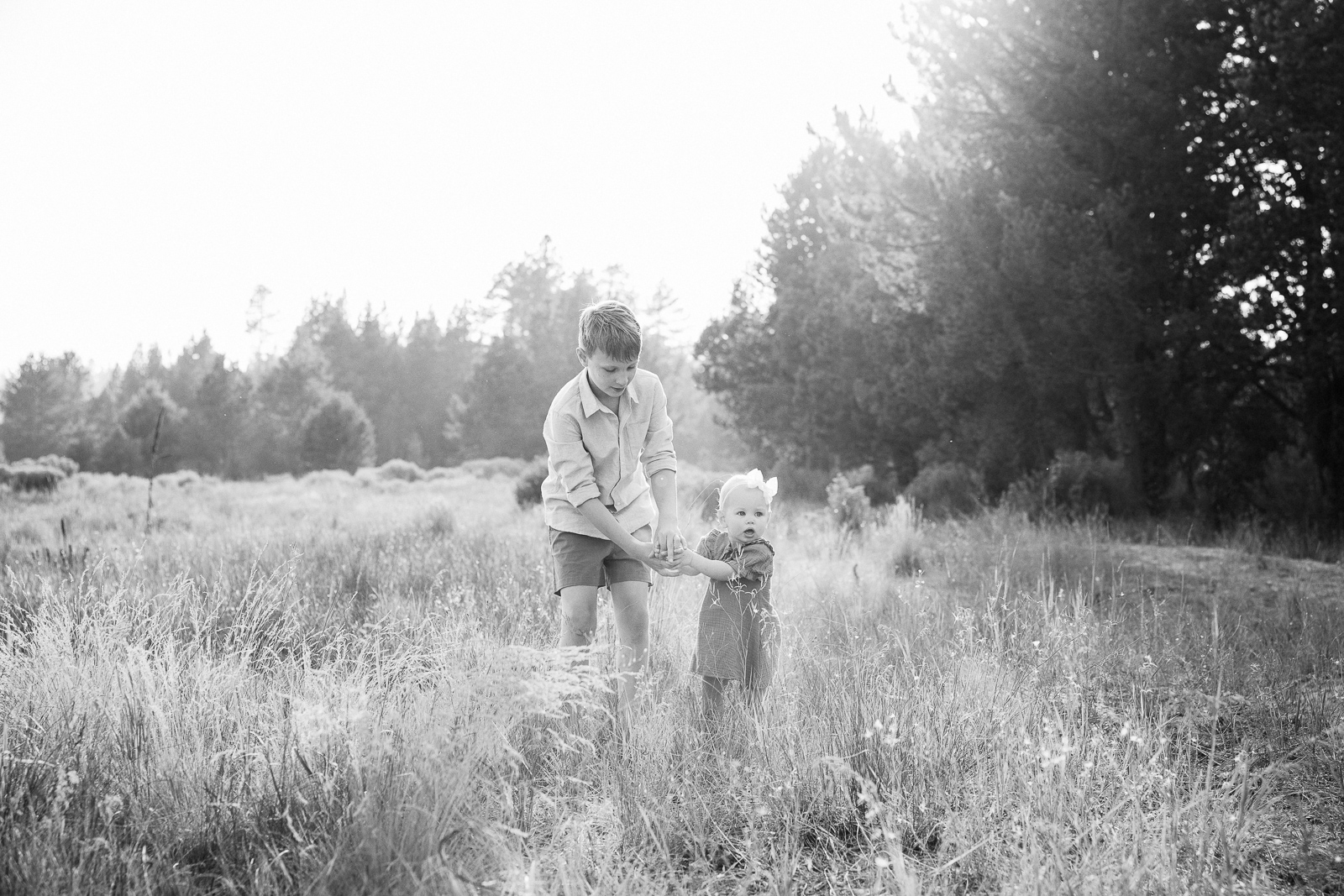 Nostalgic feeling black and white image of small siblings holding hands.
