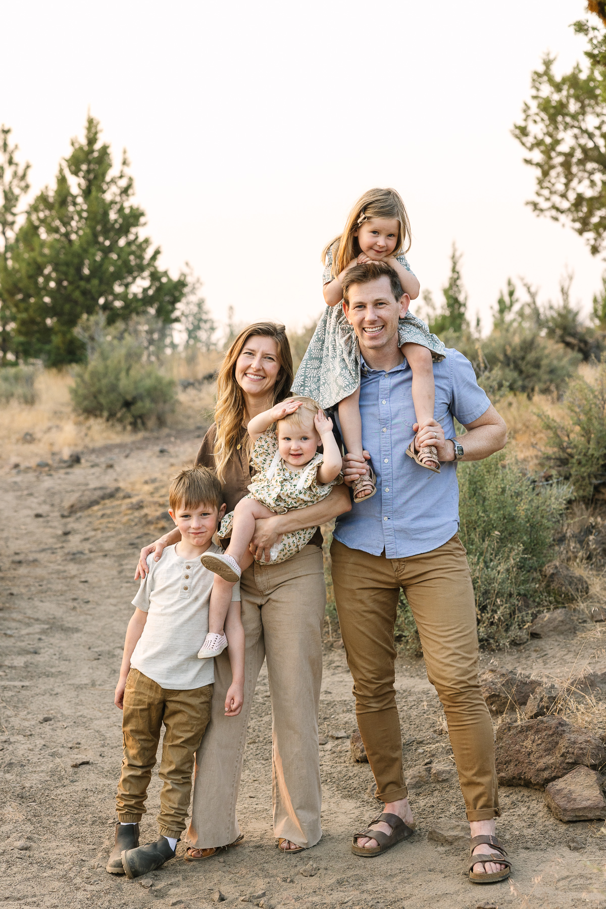 A young family of five casually poses for a portrait in nature by Bend Photographer.