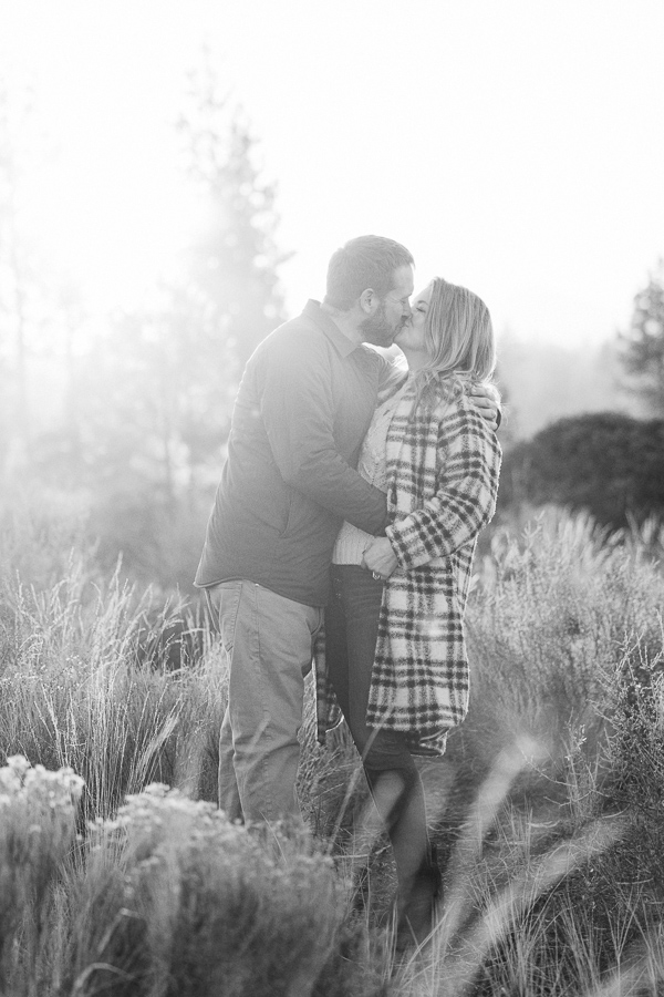 A black and white photographer of a couple kissing.