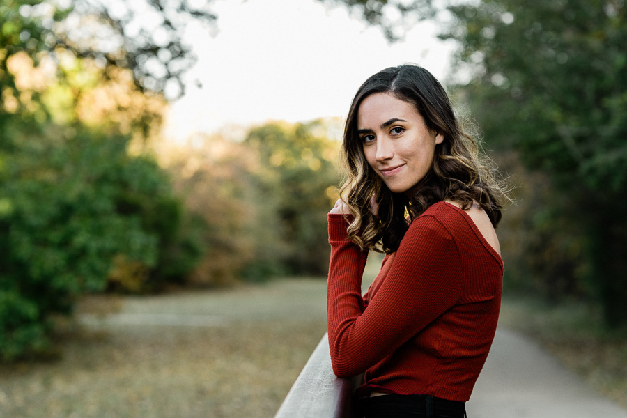 Portrait of a high school senior with maroon shirt and dark hair.