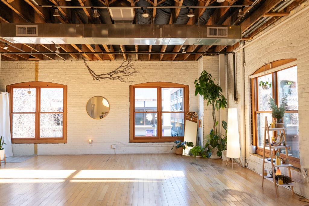 Image of the inviting Pine & Prism space featuring natural light, white brick walls and wood floors. 